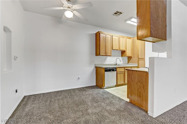 kitchen featuring light countertops, visible vents, white dishwasher, and light carpet