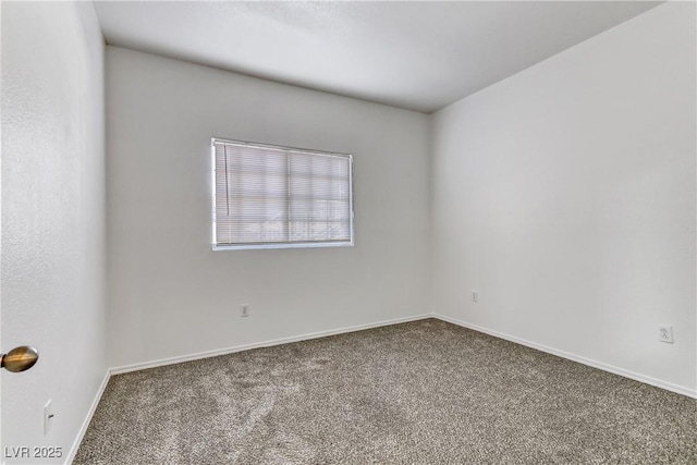 carpeted empty room featuring baseboards