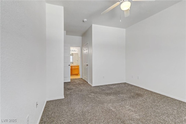 unfurnished bedroom featuring baseboards, a ceiling fan, ensuite bath, and carpet flooring