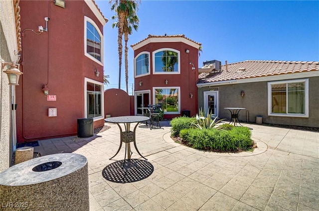 back of property featuring a patio area, stucco siding, and a tile roof