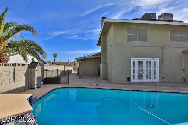 view of swimming pool featuring a fenced in pool, fence, french doors, a patio, and a gate