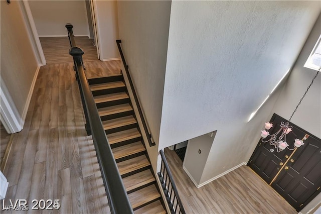 staircase with wood finished floors and baseboards