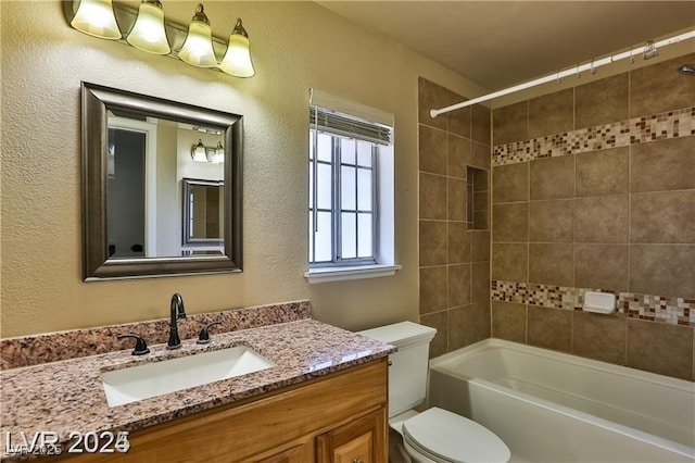 full bath featuring tub / shower combination, toilet, vanity, and a textured wall