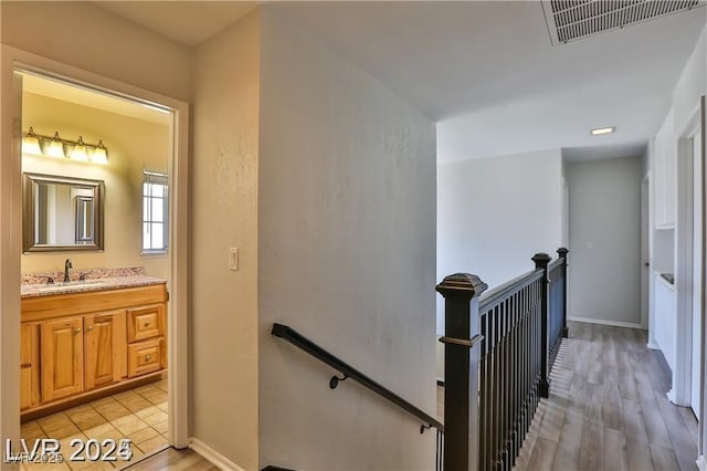 staircase with visible vents, baseboards, and wood finished floors