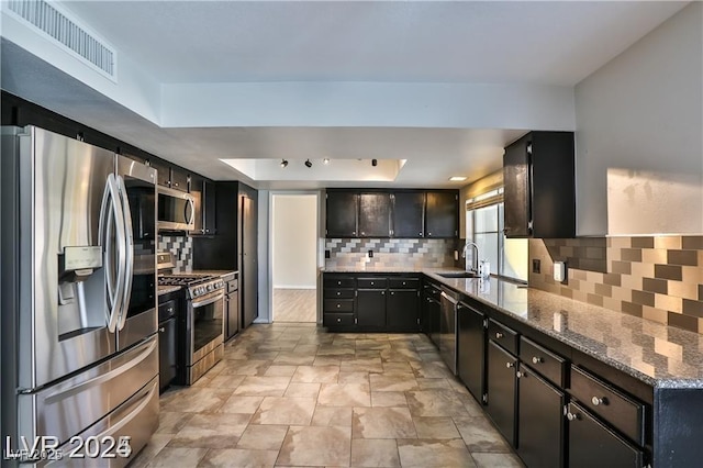 kitchen with visible vents, stone countertops, a tray ceiling, tasteful backsplash, and stainless steel appliances