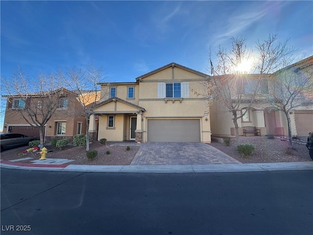 view of front of home featuring stucco siding, decorative driveway, and a garage