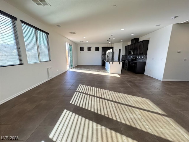 unfurnished living room with recessed lighting, visible vents, baseboards, and dark tile patterned flooring