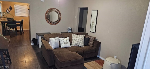 living room with dark wood-type flooring and baseboards