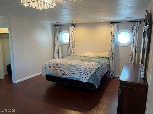 bedroom featuring visible vents, baseboards, and wood finished floors