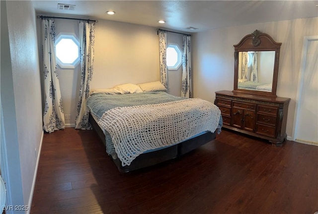 bedroom featuring visible vents, multiple windows, baseboards, and dark wood finished floors