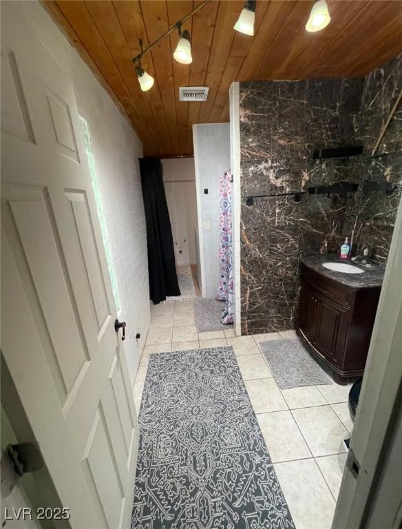 bathroom with tile patterned floors, visible vents, tile walls, wooden ceiling, and vanity