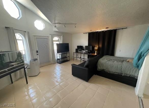 bedroom with track lighting, multiple windows, and a textured ceiling