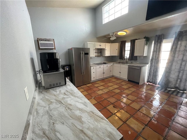 kitchen with a sink, stainless steel appliances, a wealth of natural light, and a wall mounted air conditioner