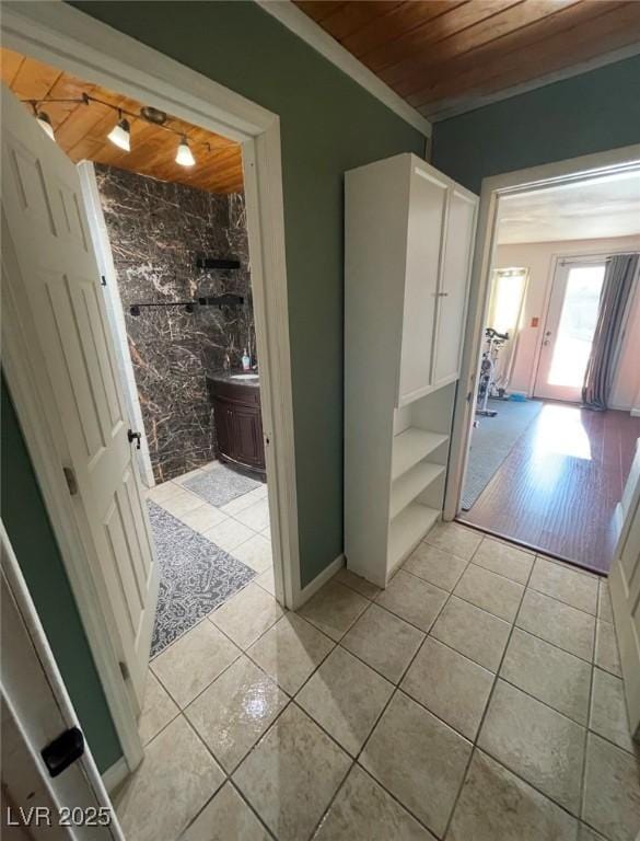 hallway with light tile patterned floors and wooden ceiling