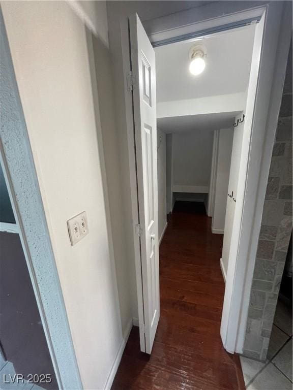 hallway featuring baseboards and wood finished floors