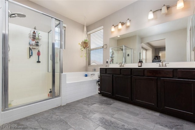 bathroom featuring a stall shower, a bath, double vanity, and a sink