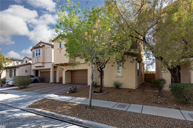 view of front facade featuring a tiled roof, stucco siding, driveway, and an attached garage