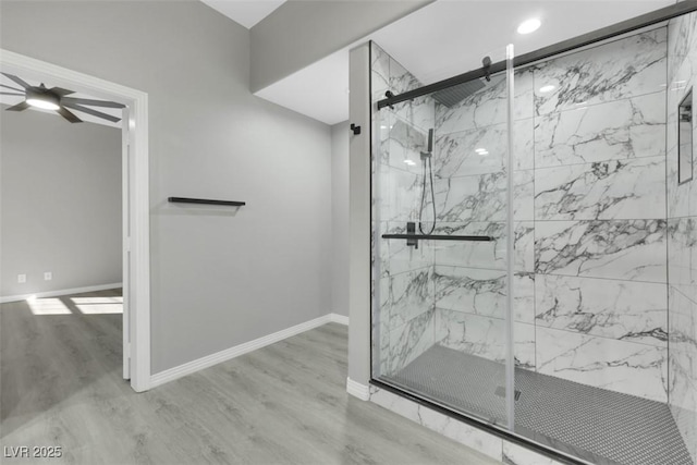 full bath with a marble finish shower, a ceiling fan, baseboards, and wood finished floors