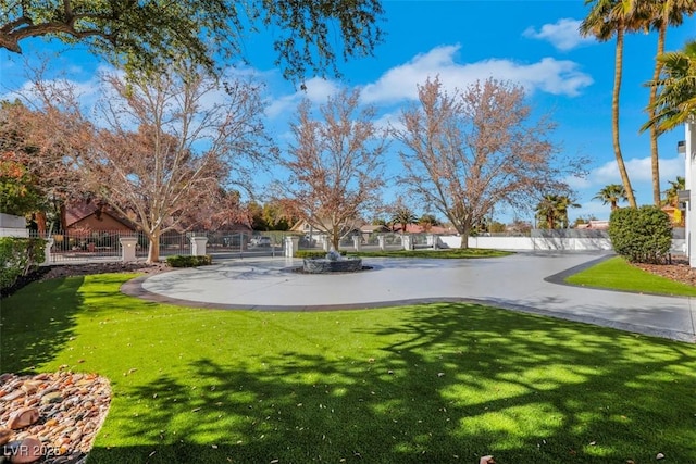 view of property's community featuring a yard and fence