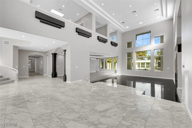 unfurnished living room with visible vents, marble finish floor, recessed lighting, arched walkways, and stairs