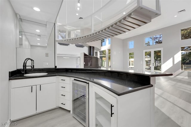 kitchen with wine cooler, visible vents, dark countertops, and a sink