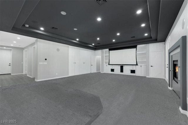 carpeted cinema room featuring recessed lighting, a tray ceiling, visible vents, and built in features