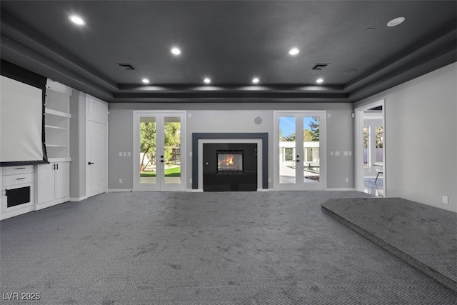 interior space featuring a tray ceiling, french doors, and visible vents