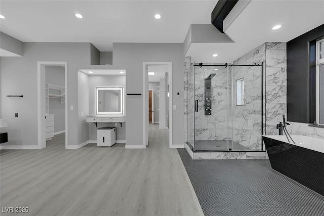 full bathroom with a marble finish shower, baseboards, wood finished floors, recessed lighting, and a freestanding tub