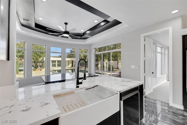 kitchen featuring light stone counters, visible vents, a tray ceiling, recessed lighting, and marble finish floor