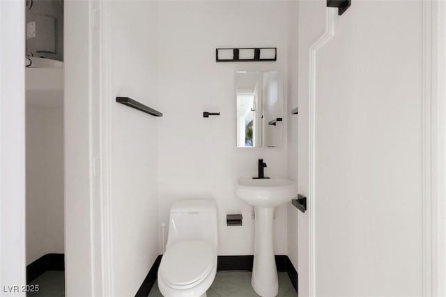 bathroom with a sink, baseboards, and toilet