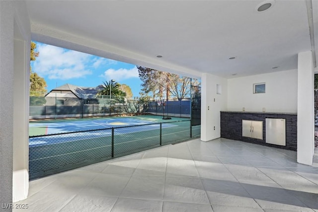 view of sport court featuring an outdoor kitchen and fence