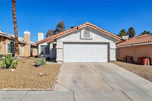 mediterranean / spanish-style home with stucco siding, driveway, a tile roof, and an attached garage