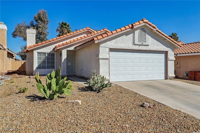 mediterranean / spanish-style house with an attached garage, a chimney, driveway, and stucco siding