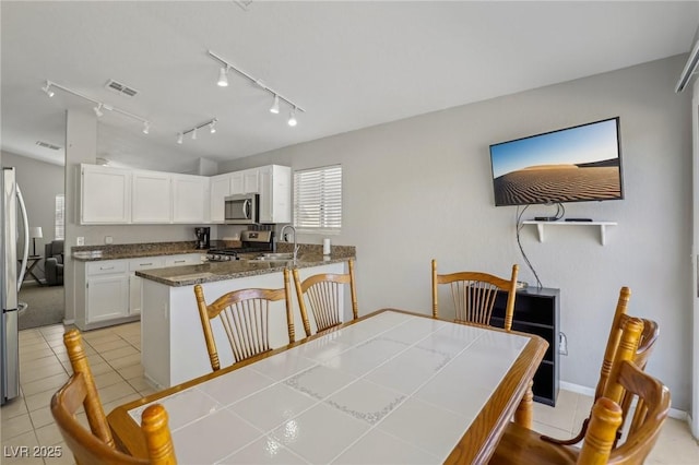 dining space with light tile patterned floors and visible vents