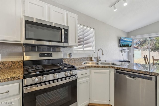 kitchen featuring a sink, stainless steel appliances, white cabinets, and vaulted ceiling