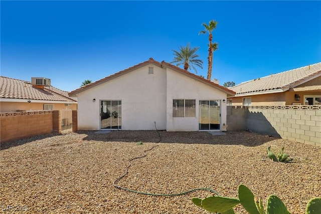 back of property featuring a gate, a fenced backyard, and stucco siding