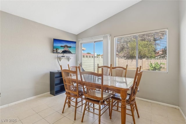 dining area featuring lofted ceiling, light tile patterned floors, and baseboards