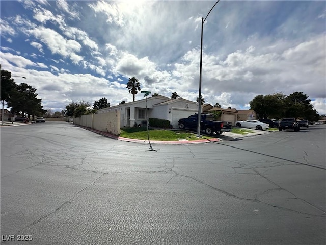 view of road featuring curbs, a residential view, street lights, and sidewalks