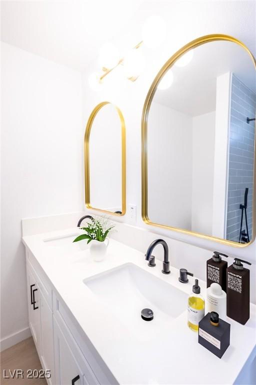 full bathroom with double vanity and a sink