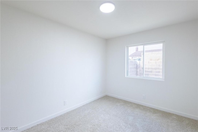 spare room with baseboards and carpet