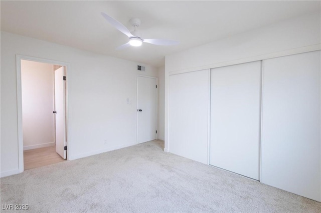 unfurnished bedroom with visible vents, connected bathroom, a closet, carpet, and ceiling fan