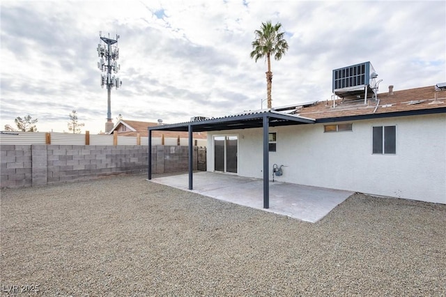 rear view of house featuring central AC unit, a patio area, fence, and stucco siding