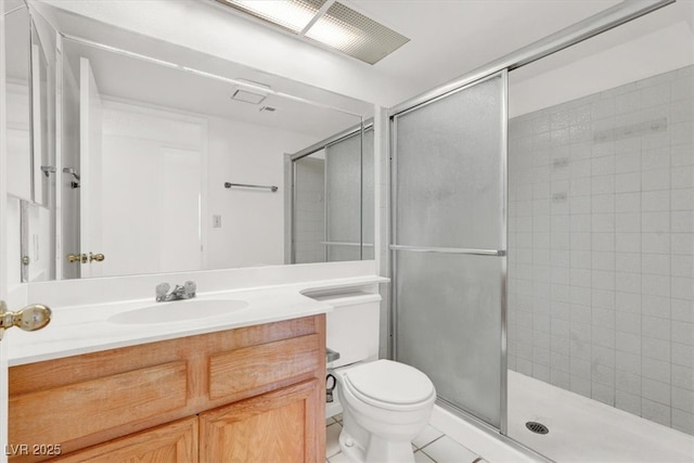 bathroom featuring vanity, a shower stall, toilet, and tile patterned flooring