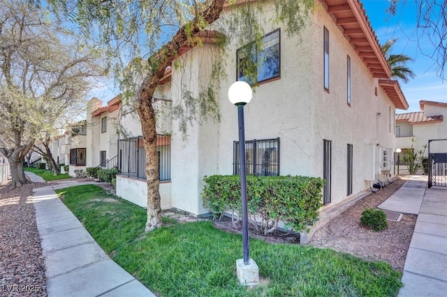 view of property exterior featuring a gate, fence, and stucco siding