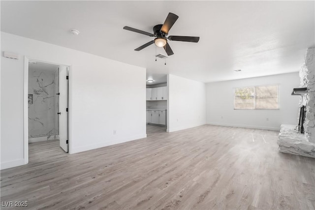 unfurnished living room with visible vents, baseboards, ceiling fan, light wood-type flooring, and a fireplace