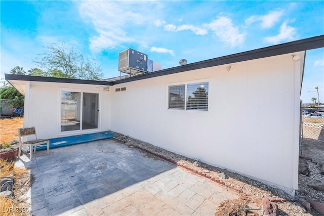 rear view of house with central AC unit and a patio area