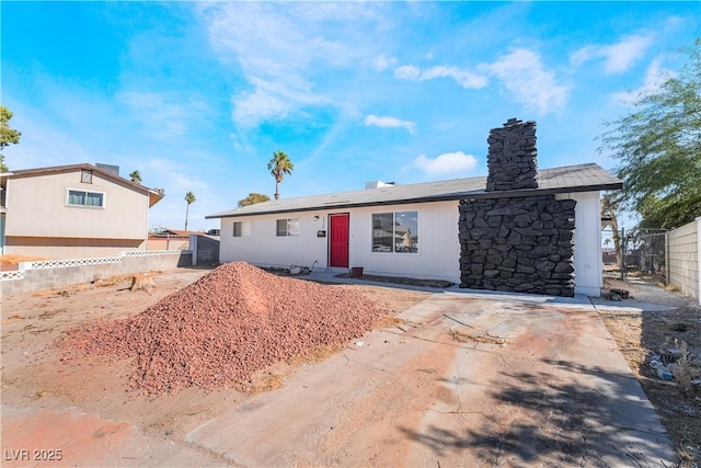 ranch-style house with fence and a chimney