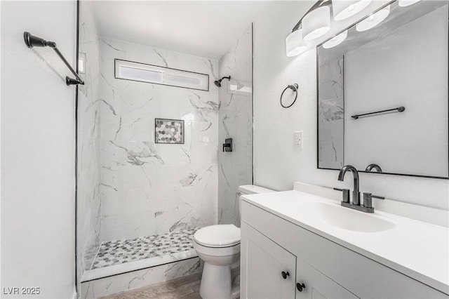 full bath featuring vanity, toilet, and a marble finish shower