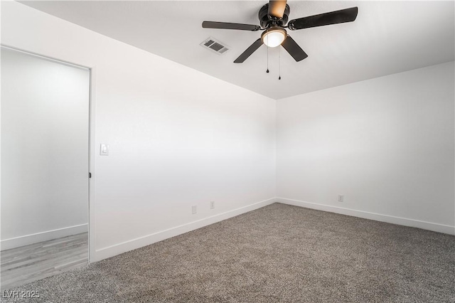 carpeted empty room with visible vents, baseboards, and ceiling fan