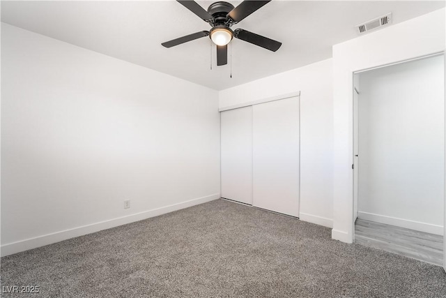 unfurnished bedroom featuring carpet flooring, baseboards, visible vents, and a closet